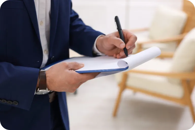 Home inspector in professional attire writing notes on a clipboard — representing certified and trained home inspectors in Orlando, FL.