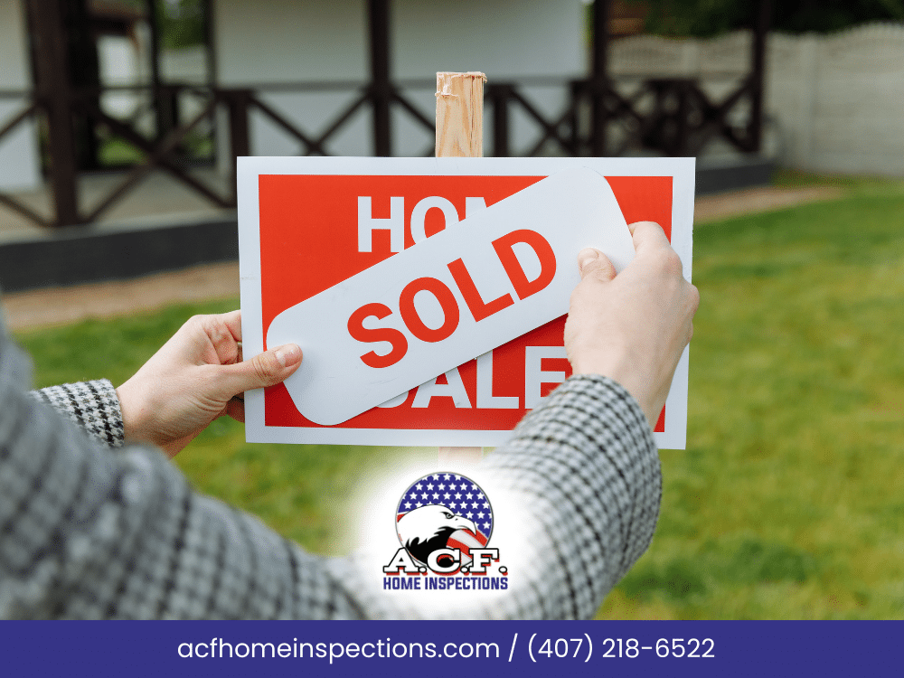 A.C.F. Home Inspections Home inspector placing a 'SOLD' sign on a property after a successful sale